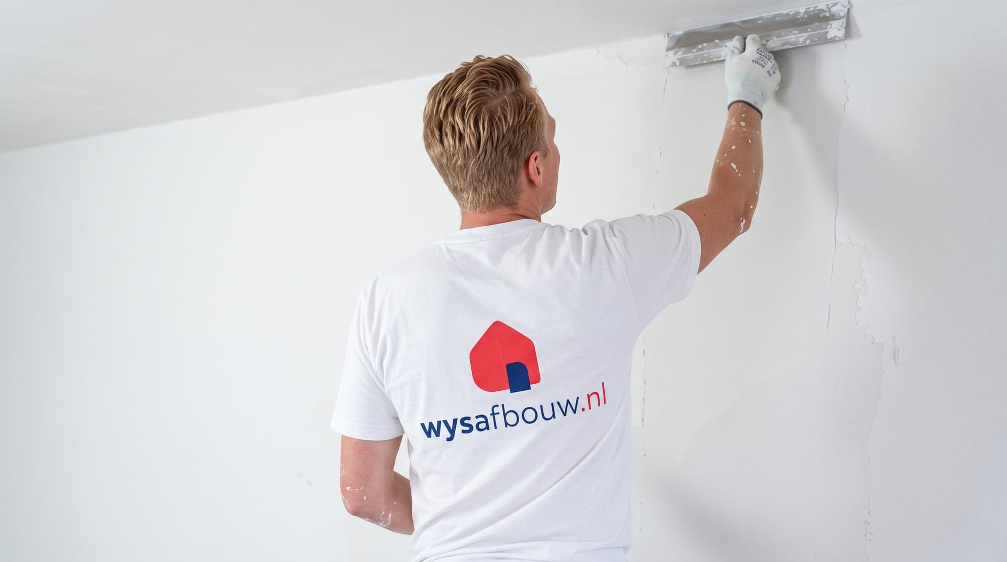 Stukadoor van WYS Afbouw werkt een wand af
