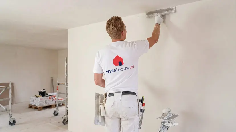 Stukadoor van WYS Afbouw werkt een wand af