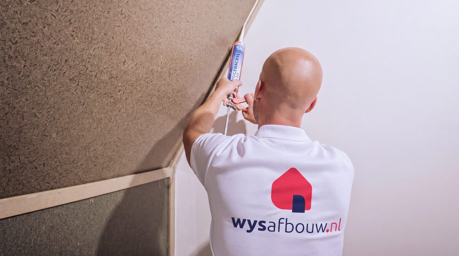 Vakman van WYS Afbouw werkt een naad af